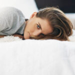 Cropped portrait of a beautiful young woman relaxing on her bed