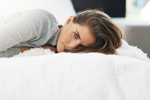 Cropped portrait of a beautiful young woman relaxing on her bed